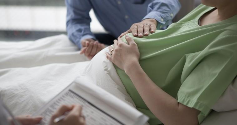 Lekarz zapisuje informacje przy kobiecie w ciąży