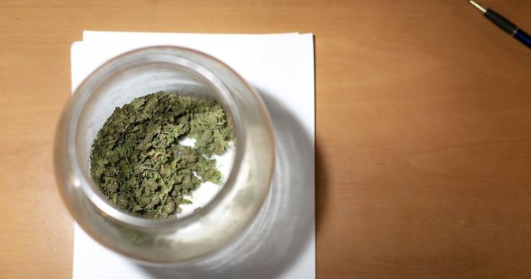 Słoik z leczniczą marihuaną stoi na stole. 