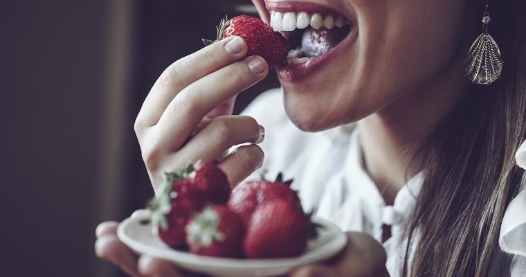 Kobieta jedząca truskawki. Monodieta truskawkowa 