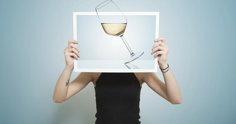 Kobieta, która trzyma obrazek z kieliszkiem wina