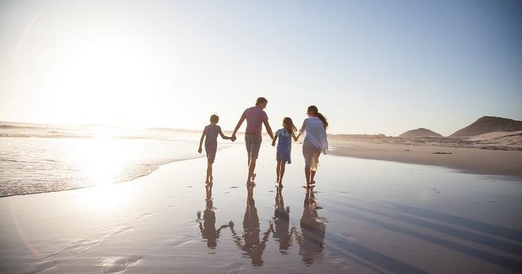 rodzice z dziećmi spacerują po plaży 