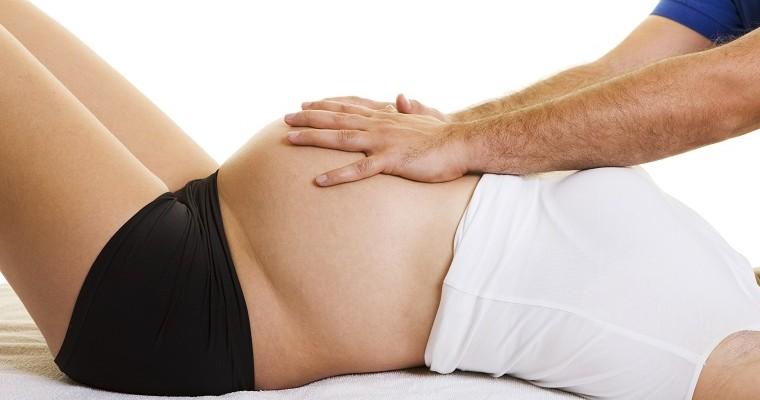 fizjoterapeuta masuje brzuch kobiety w ciąży 