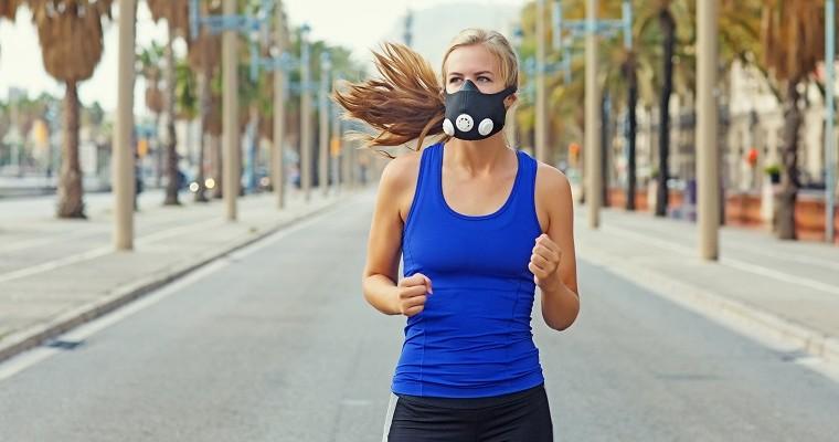 młoda kobieta biegnie z maską na twarzy. 