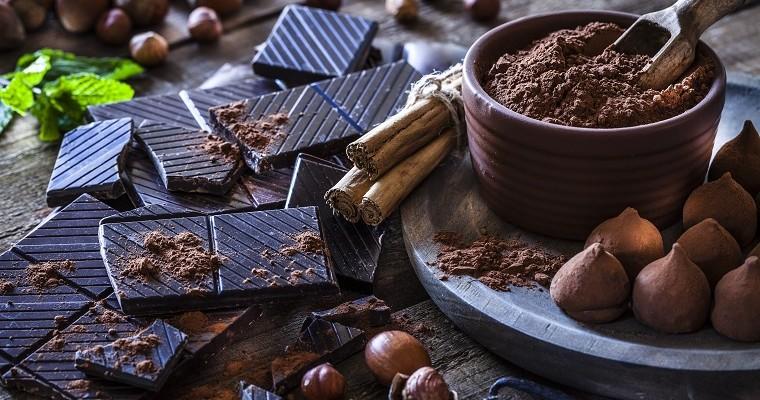 czekolada w kawałkach leży obok talerza na którym jest kakao