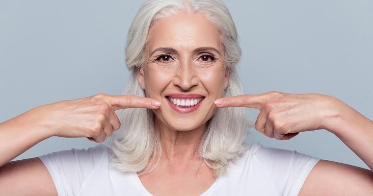 uśmiechnięta kobieta pokazuje zdrowie białe zęby 
