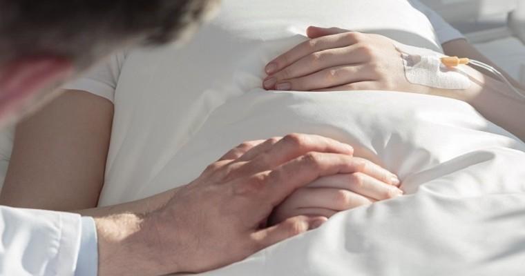 Mąż trzyma za rękę żonę chorą na białaczkę