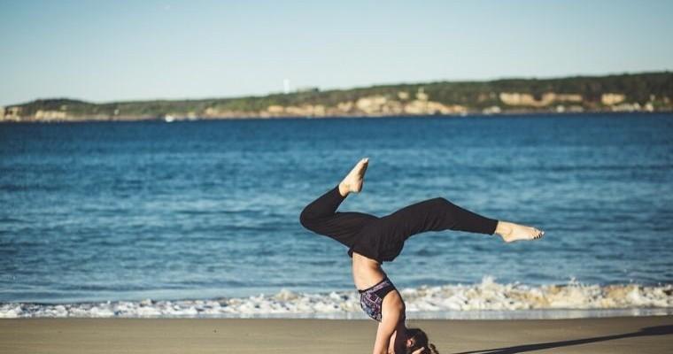 młoda kobieta ćwiczy jogę na plaży 