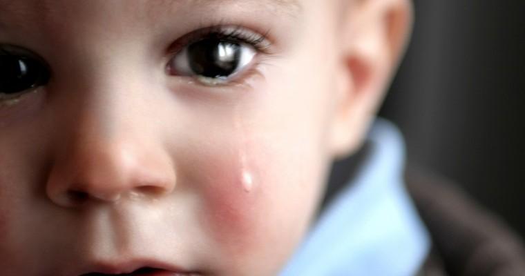 Płaczące dziecko na ciemnym tle